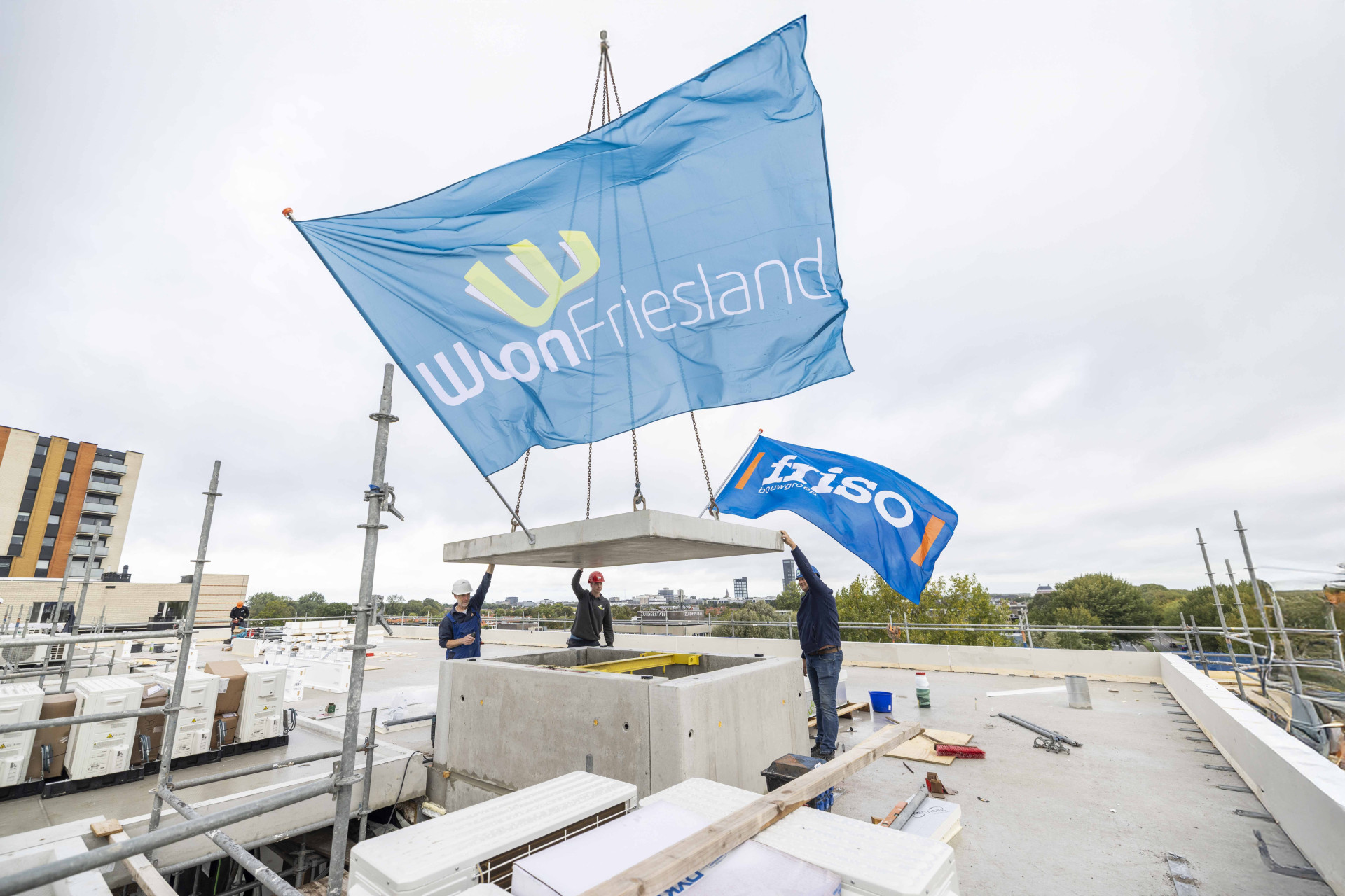 De vlag wappert bovenop het nieuwe appartementengebouw van WoonFriesland aan de Aldlânsdyk in Leeuwarden.