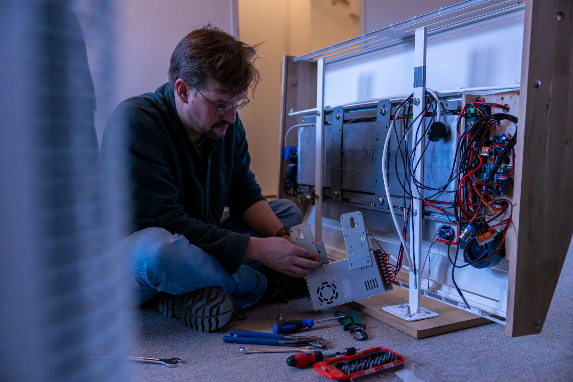 Een persoon werkt aan een elektronisch apparaat.
