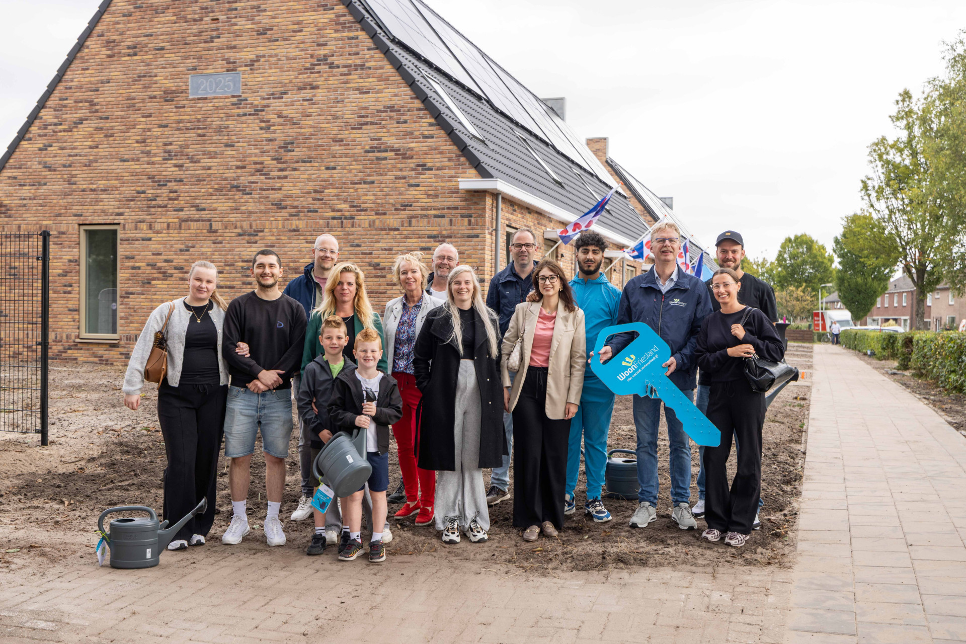 Vrolijke gezichten bij de sleuteloverdracht van de woningen aan It Eilânsgrien in Earnewâld.