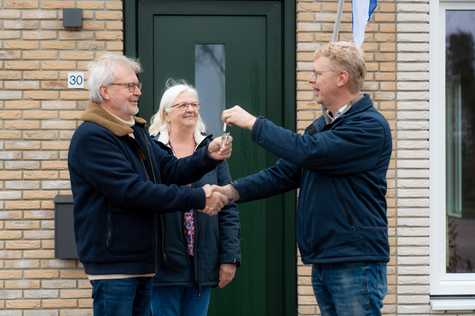 Terugkerende bewoners krijgen de sleutel uitgereikt van hun nieuwe woning aan de Master Lubwei in Garyp.