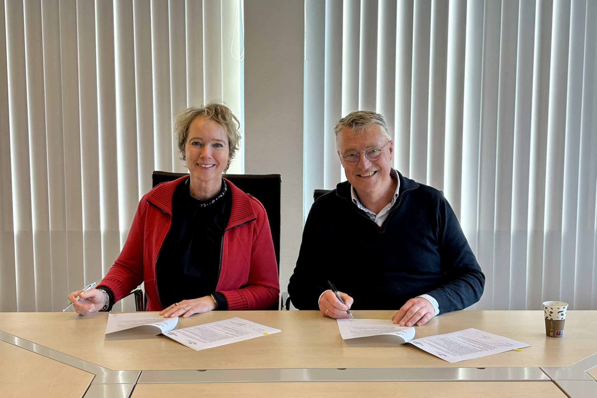 Sigrid Hoekstra en Gert Brouwer, voorzitter van Huurdersbelang Fryslân, ondertekenen een samenwerkingsovereenkomst.